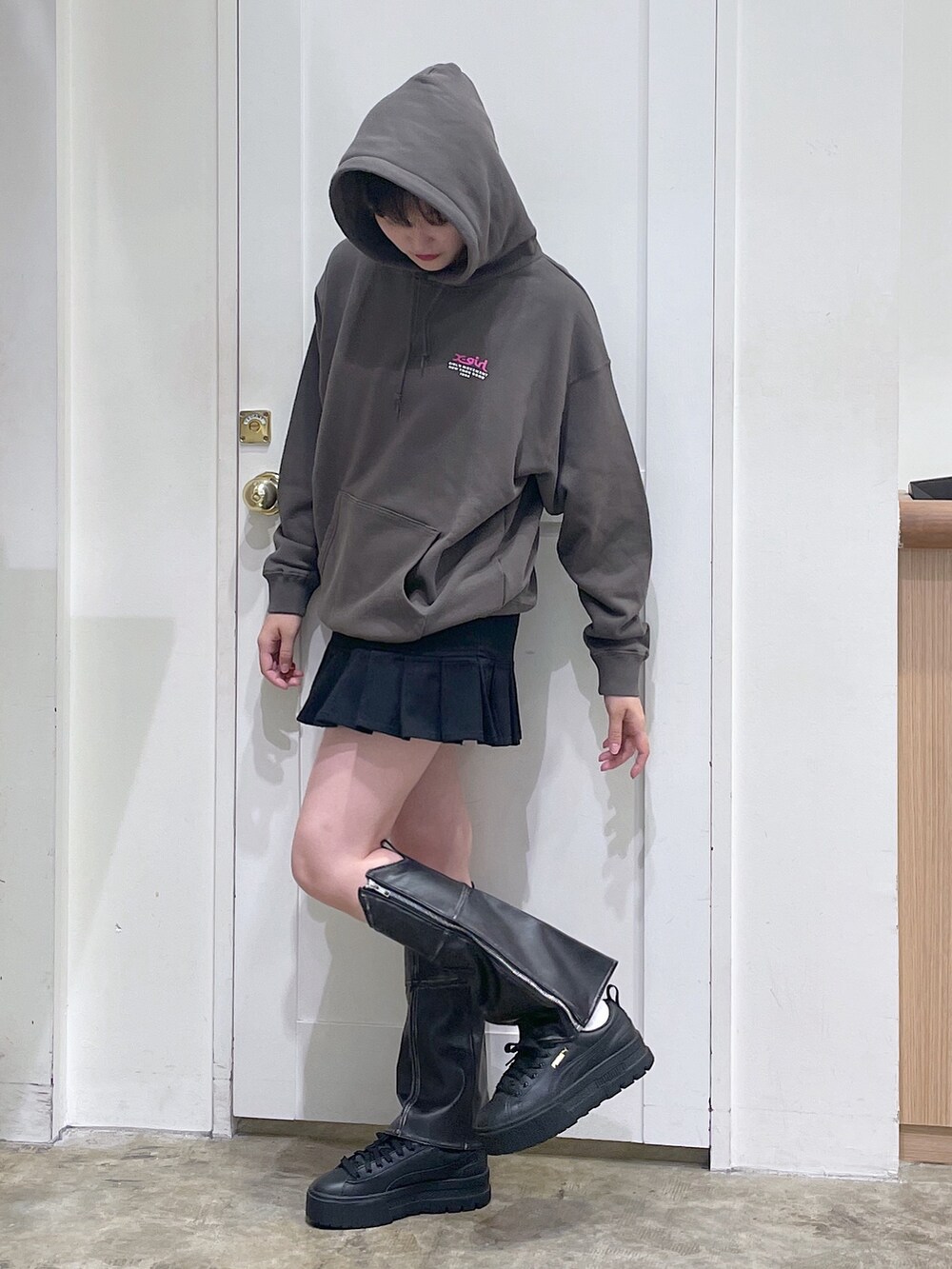 グリーン系のパーカー、ブラック系のスカート、ブラック系のレッグウォーマーを着用したメンズの秋コーディネートの2枚目の写真