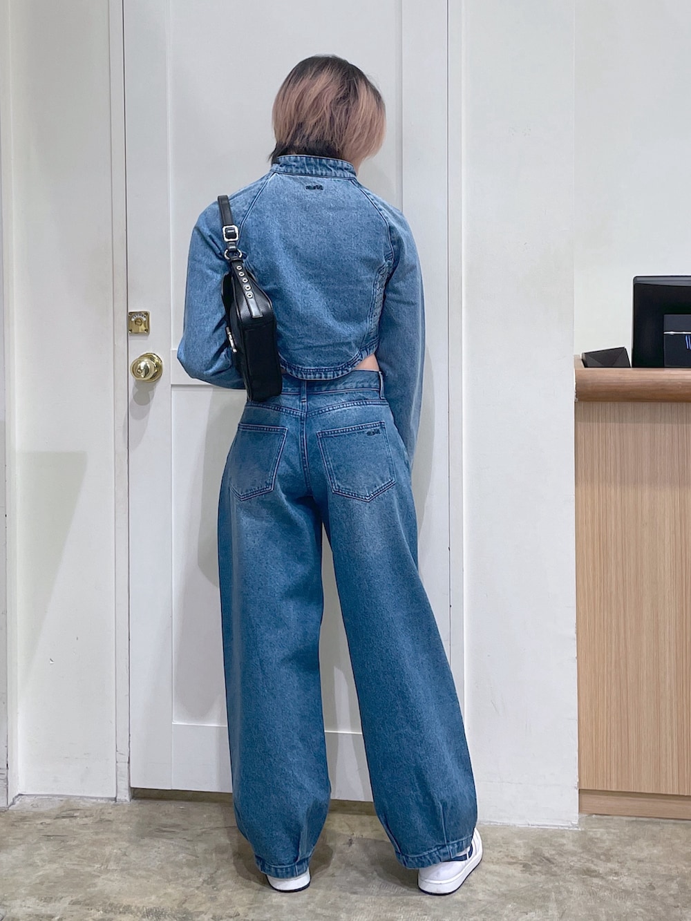 ブラック系のショルダーバッグ、ブルー系のデニムパンツ、ブルー系のデニムジャケットを着用したメンズの秋コーディネートの3枚目の写真