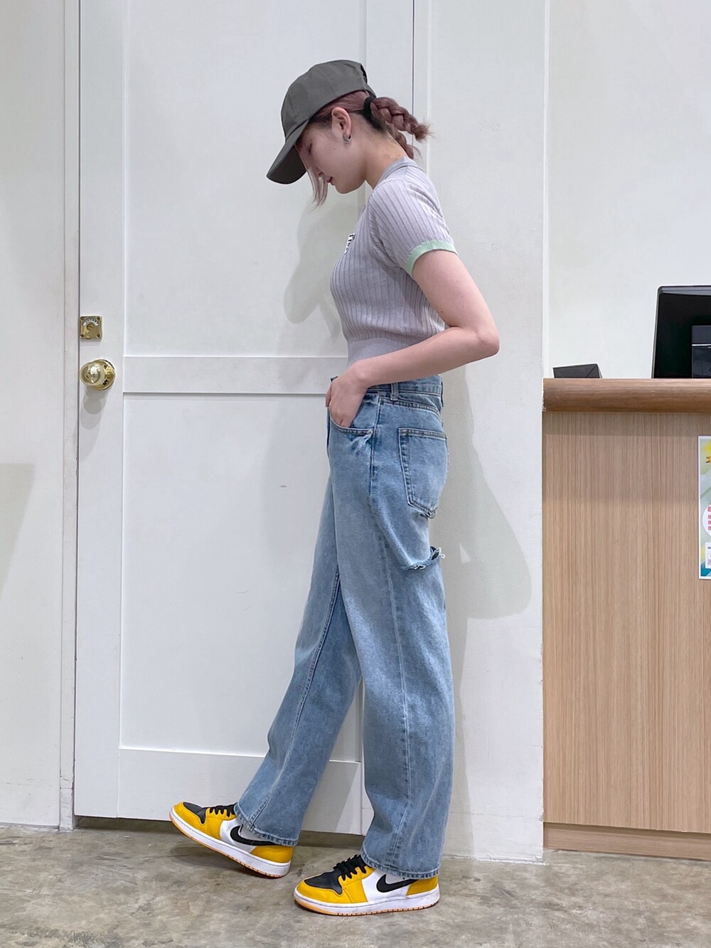 グレー系のポロシャツ、ブルー系のデニムパンツ、グリーン系のキャップを着用したメンズの春コーディネートの2枚目の写真