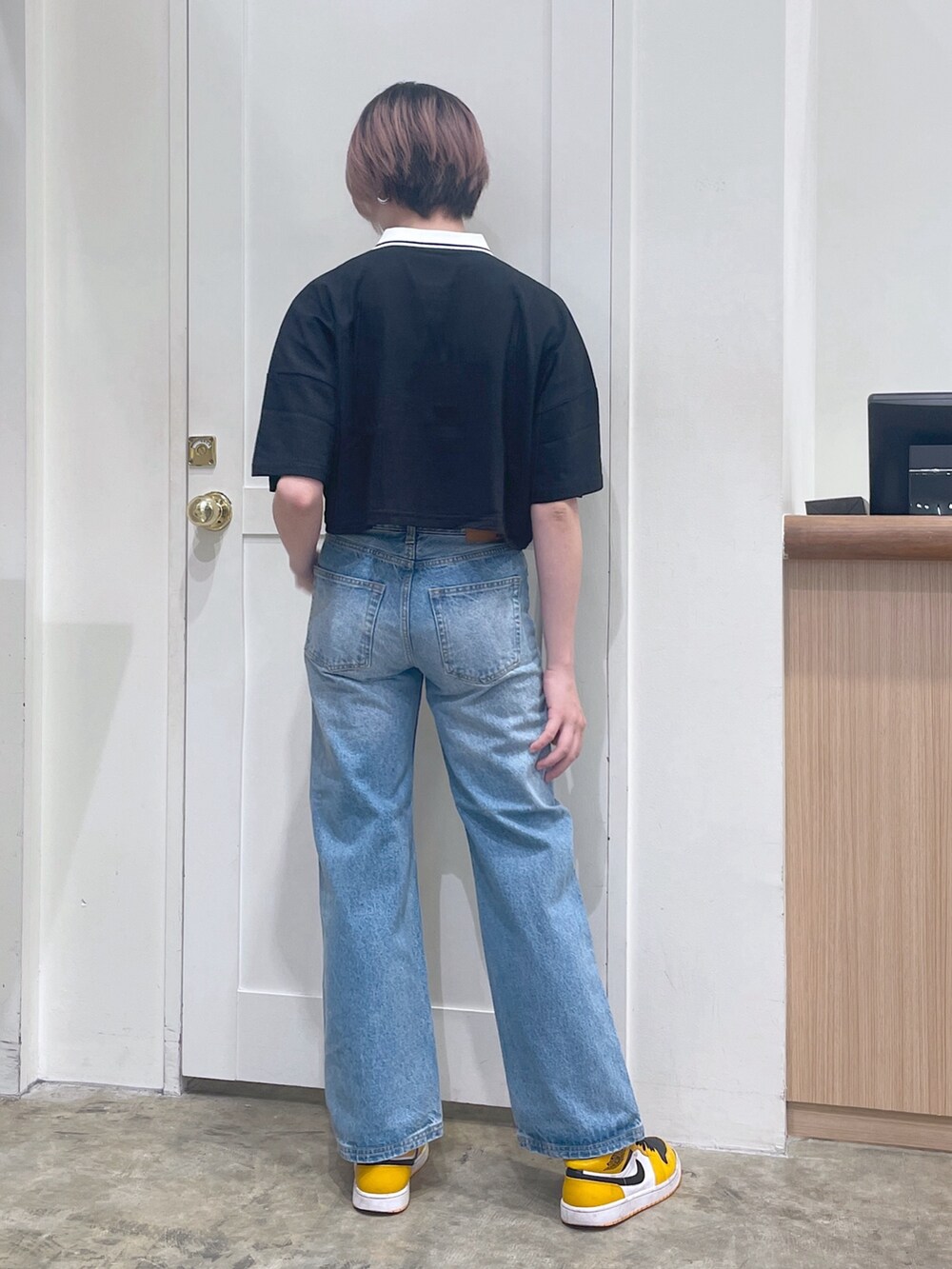 ブラック系のポロシャツ、ブルー系のデニムパンツ、シルバー系のカードケースを着用したメンズの夏コーディネートの3枚目の写真