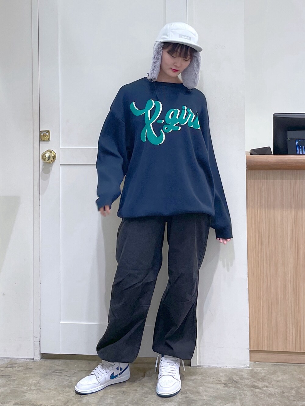 ブルー系のニット/セーター、ブラック系のその他パンツ、ホワイト系のキャップを着用したメンズの秋コーディネートの2枚目の写真