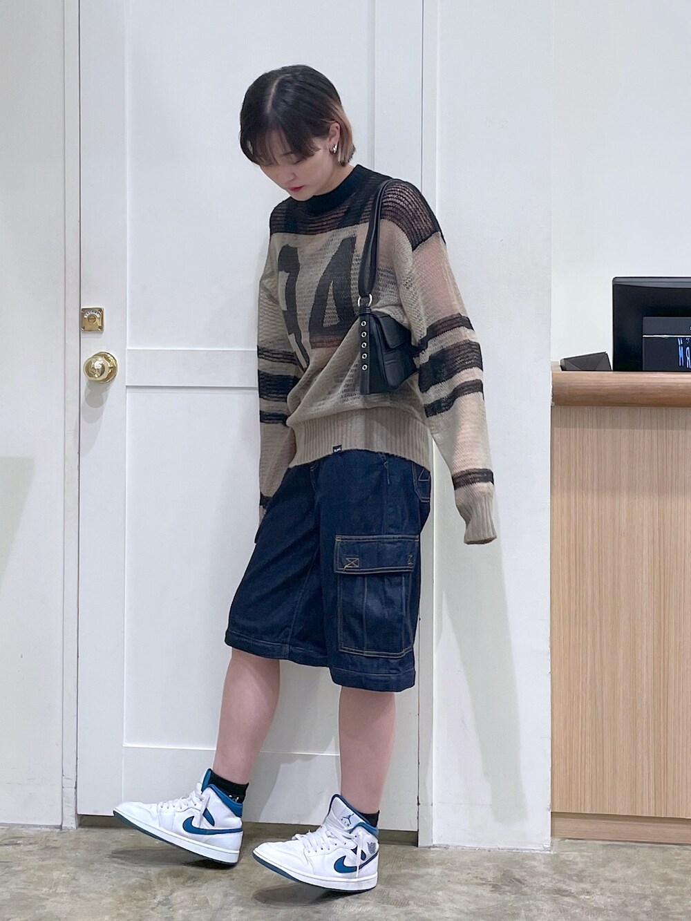 グリーン系のニット/セーター、グリーン系のタンクトップ、ブラック系のショルダーバッグを着用したメンズの秋コーディネートの2枚目の写真