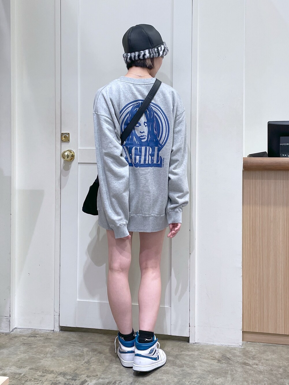 グレー系のスウェット、ブラック系のショルダーバッグ、ホワイト系のハットを着用したメンズの秋コーディネートの4枚目の写真