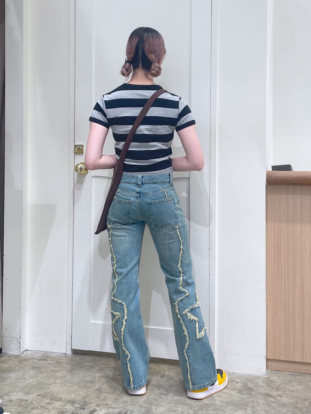 ブラック系のTシャツ/カットソー、ブラウン系のショルダーバッグ、ブルー系のデニムパンツを着用したメンズの春コーディネートの3枚目の写真