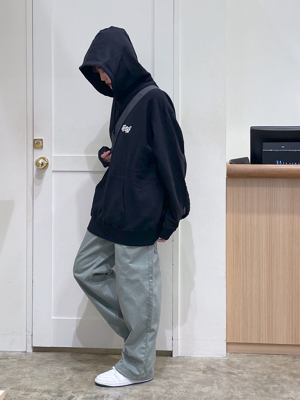 ブラック系のショルダーバッグ、ブラック系のパーカー、グリーン系のその他パンツを着用したメンズの秋コーディネートの2枚目の写真