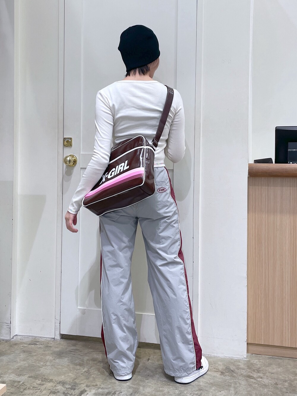 ホワイト系のTシャツ/カットソー、グレー系のその他パンツ、ブラウン系のショルダーバッグを着用したメンズの秋コーディネートの3枚目の写真