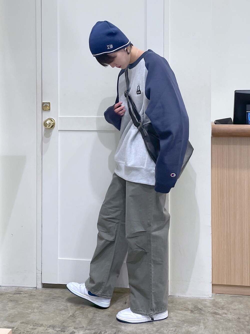 グレー系のスウェット、ブラック系のショルダーバッグ、グリーン系のその他パンツを着用したメンズの秋コーディネートの3枚目の写真