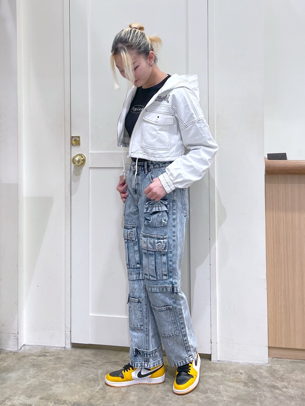 ブルー系のデニムパンツ、ホワイト系のブルゾン、ブラック系のTシャツ/カットソーを着用したレディースの春コーディネートの2枚目の写真