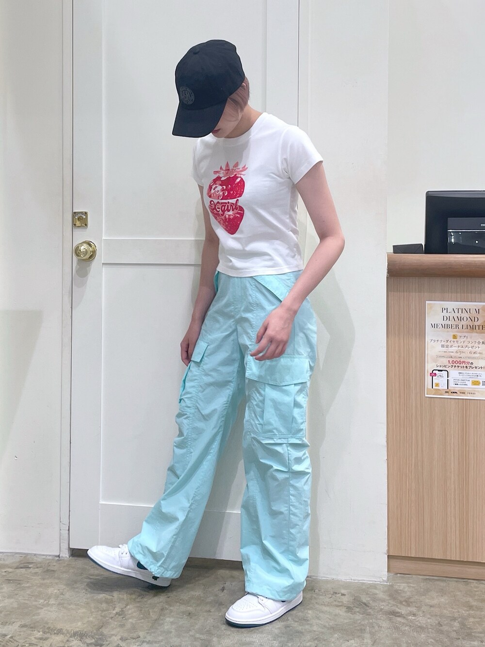 グリーン系のカーゴパンツ、ホワイト系のTシャツ/カットソー、ブラック系のキャップを着用したレディースの夏コーディネートの2枚目の写真