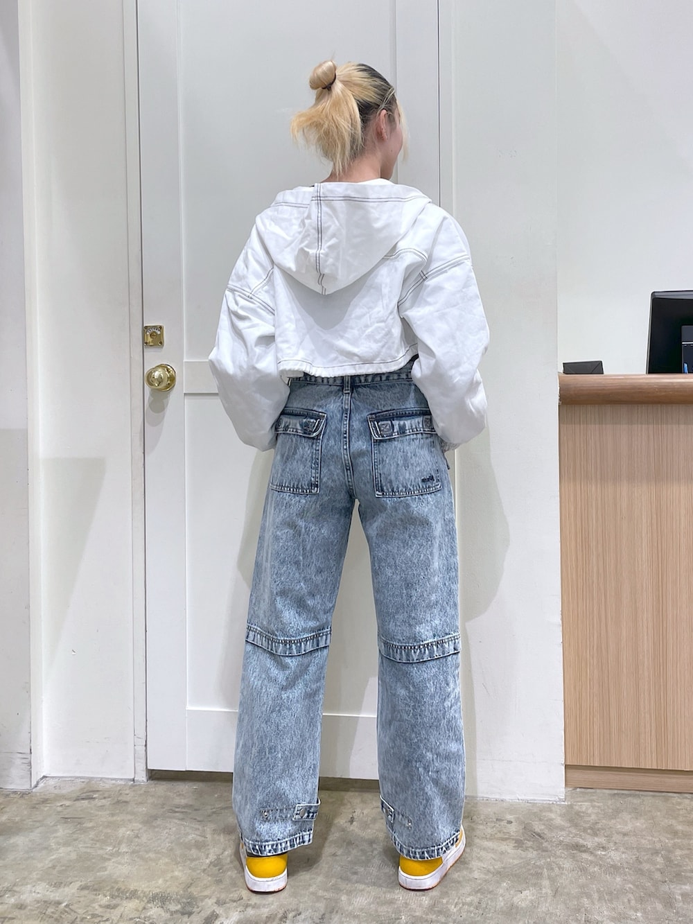 ブルー系のデニムパンツ、ホワイト系のブルゾン、ブラック系のTシャツ/カットソーを着用したレディースの春コーディネートの3枚目の写真