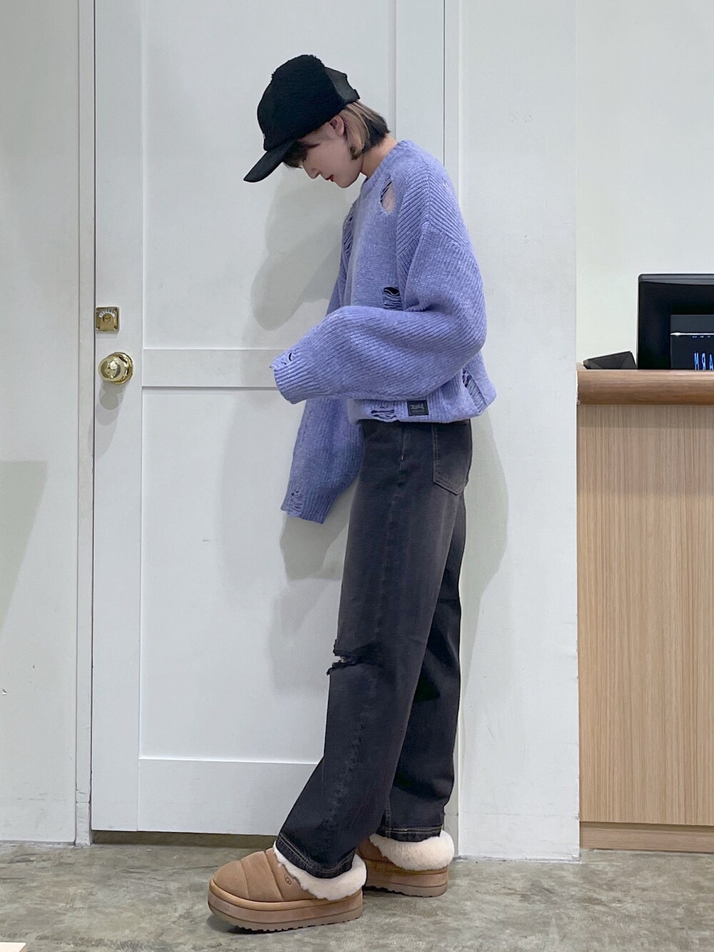 パープル系のニット/セーター、ブラック系のデニムパンツ、ブラック系のキャップを着用したメンズの冬コーディネートの2枚目の写真