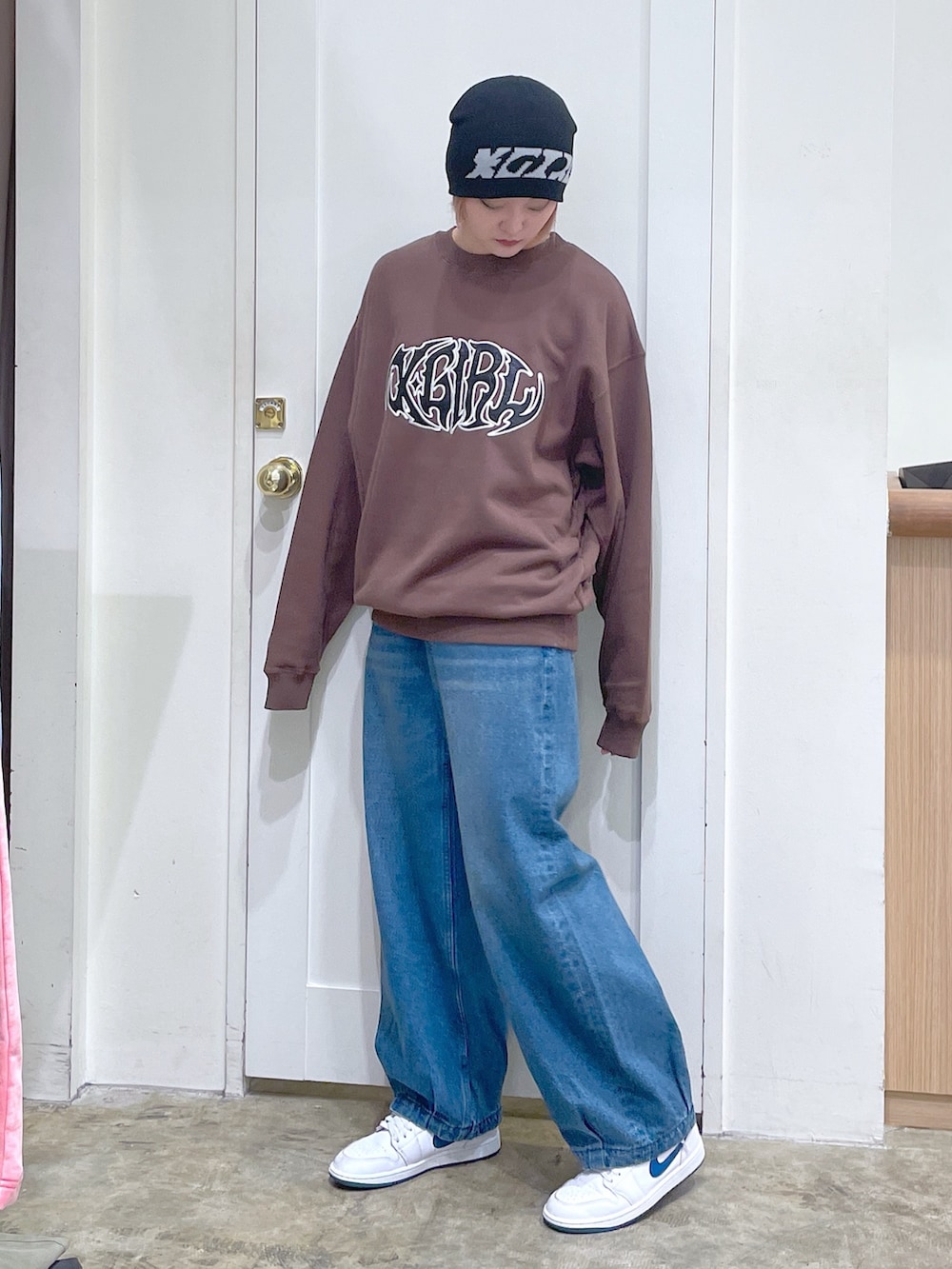 ブラウン系のスウェット、ブルー系のデニムパンツ、ブラック系のニットキャップ/ビーニーを着用したメンズの秋コーディネートの2枚目の写真