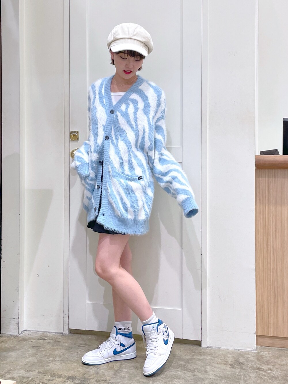 ブルー系のカーディガン/ボレロ、ホワイト系のTシャツ/カットソー、ブラック系のスカートを着用したメンズの秋コーディネートの2枚目の写真