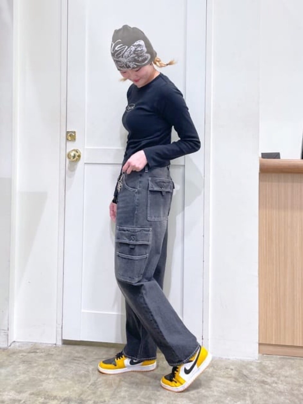 ブラック系のカーゴパンツ、ブラック系のTシャツ/カットソー、グリーン系のニットキャップ/ビーニーを着用したレディースの春コーディネートの2枚目の写真