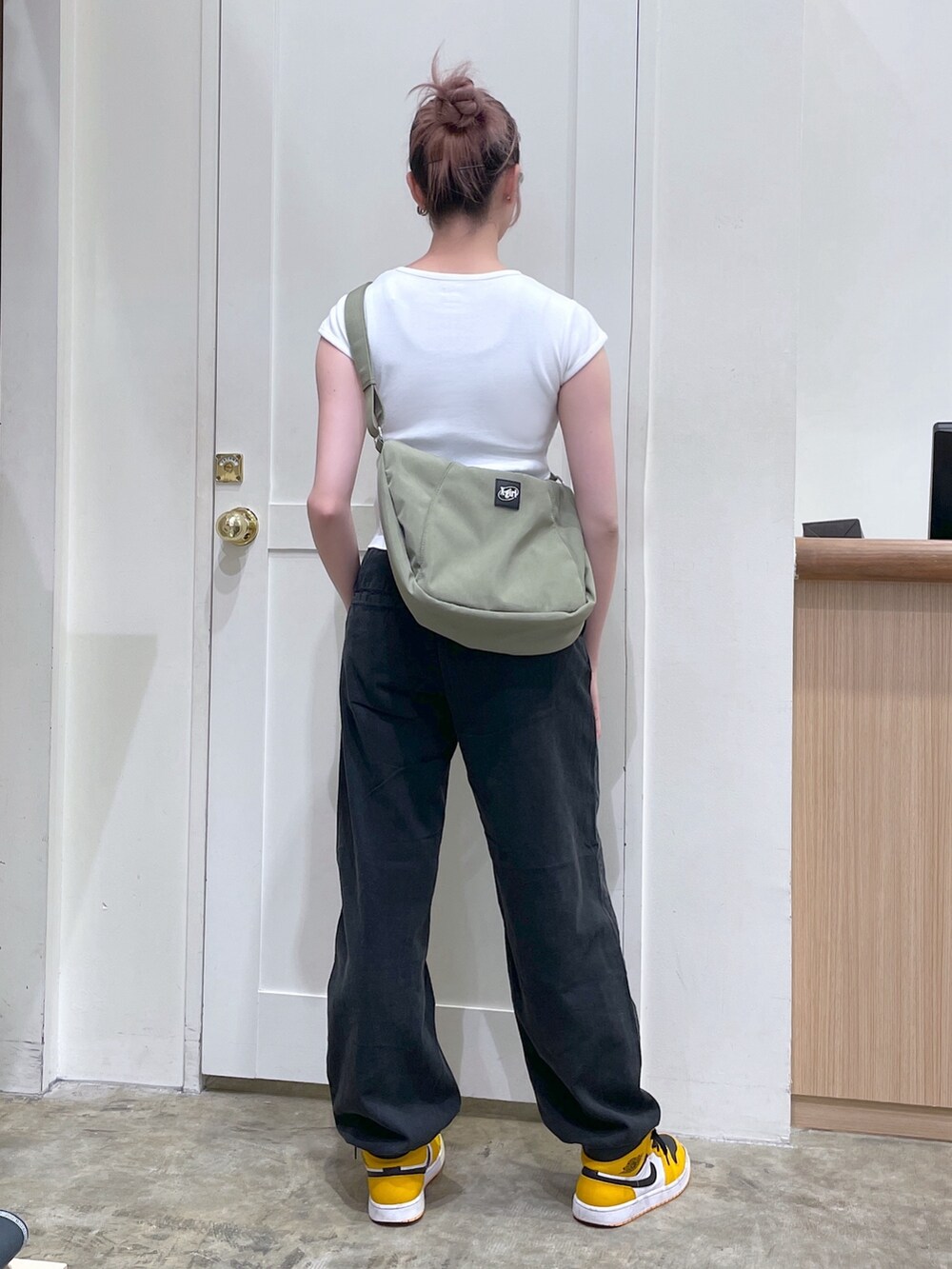 ブラック系のその他パンツ、ホワイト系のTシャツ/カットソー、グリーン系のショルダーバッグを着用したメンズの春コーディネートの4枚目の写真