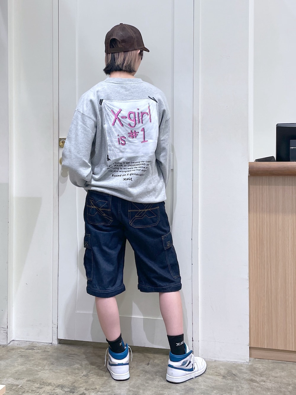グレー系のスウェット、ブルー系のデニムパンツ、ブラウン系のキャップを着用したメンズの秋コーディネートの3枚目の写真