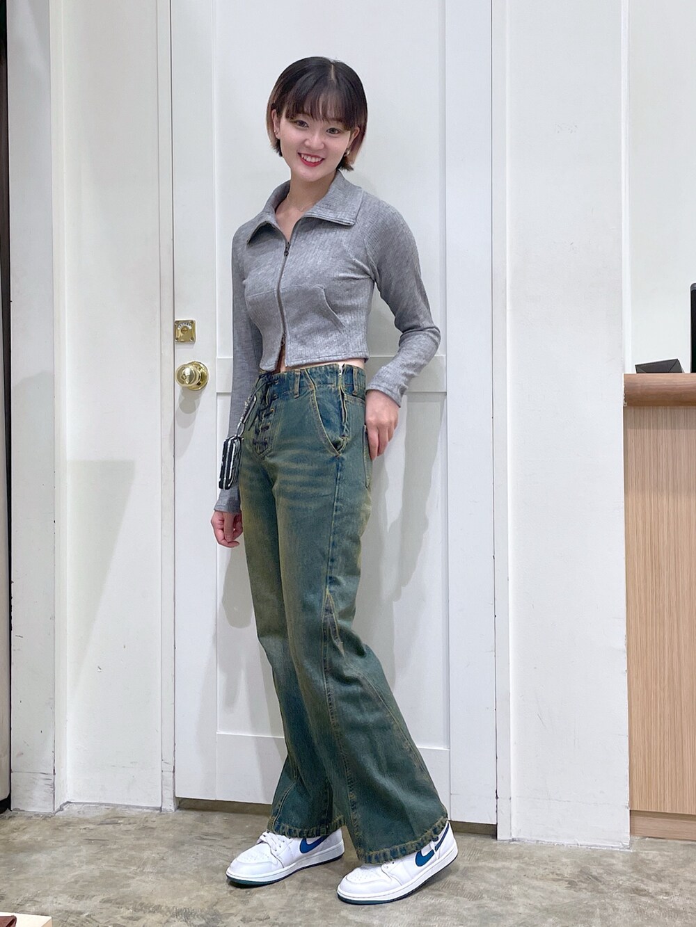 グレー系のTシャツ/カットソー、ブルー系のデニムパンツ、ホワイト系のコインケースを着用したメンズの秋コーディネートの3枚目の写真