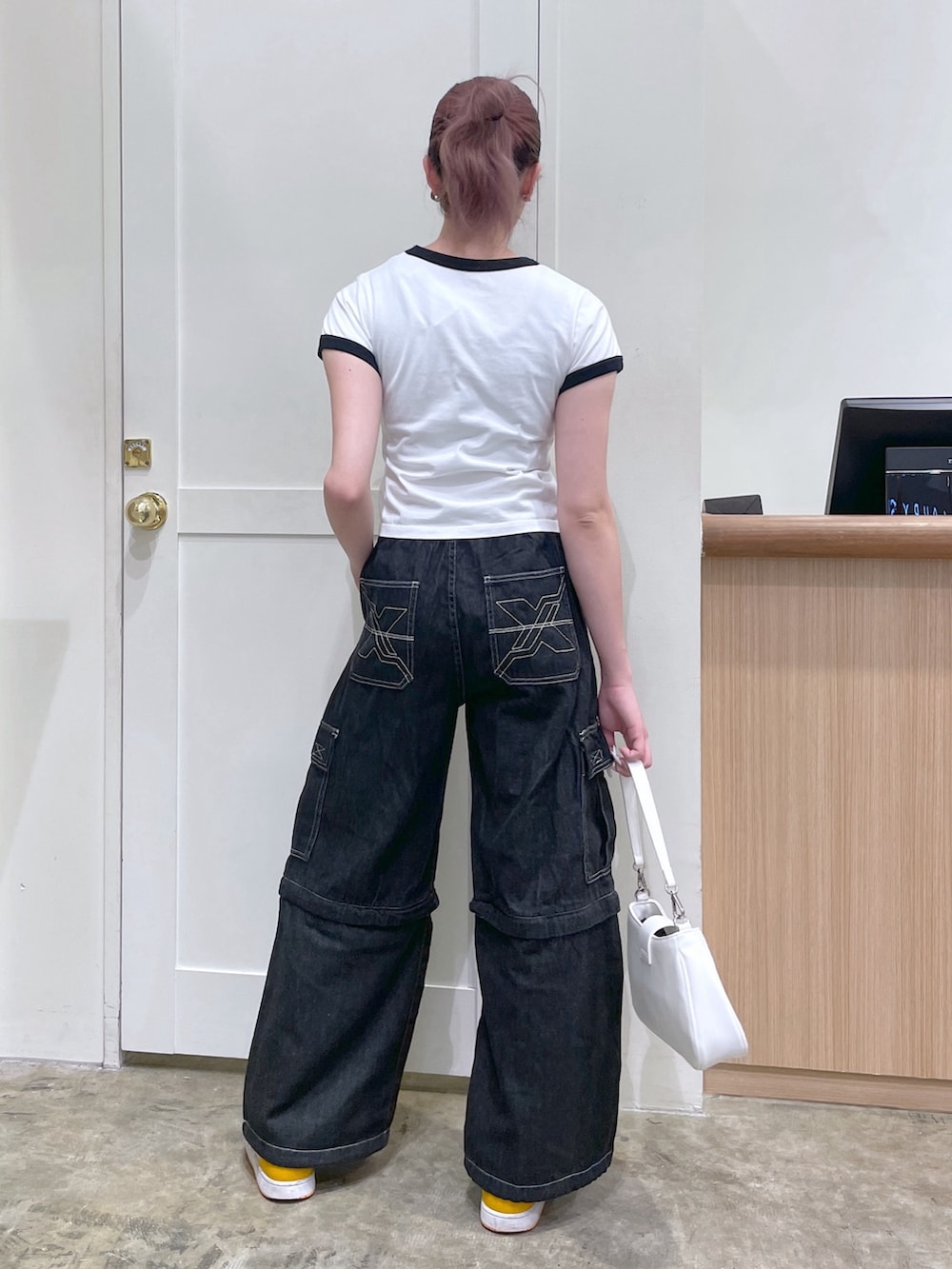 ホワイト系のTシャツ/カットソー、ブラック系のデニムパンツ、ホワイト系のショルダーバッグを着用したメンズの春コーディネートの3枚目の写真