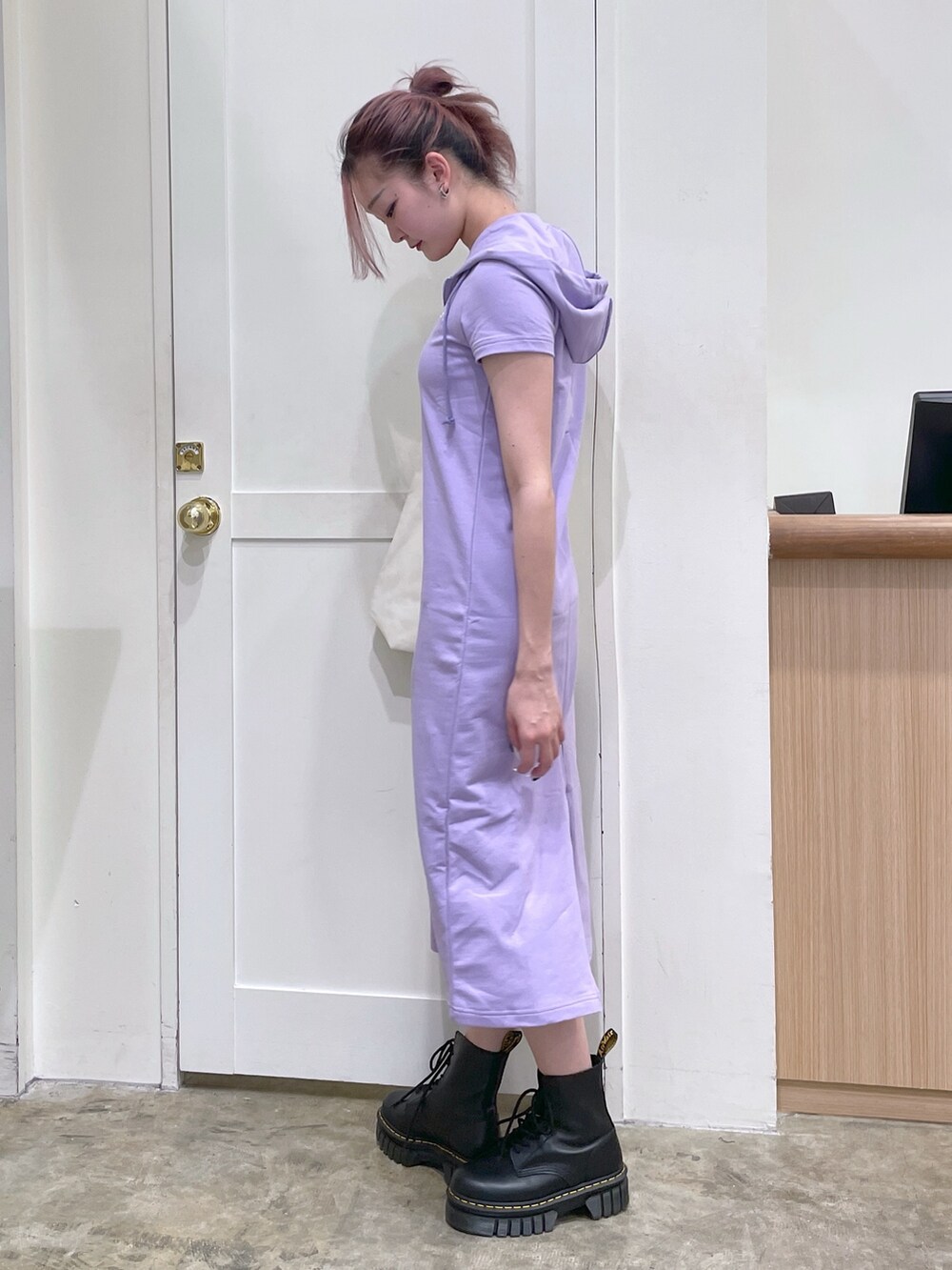 パープル系のワンピース、ホワイト系のトートバッグ、ブラック系のブーツを着用したメンズの春コーディネートの2枚目の写真