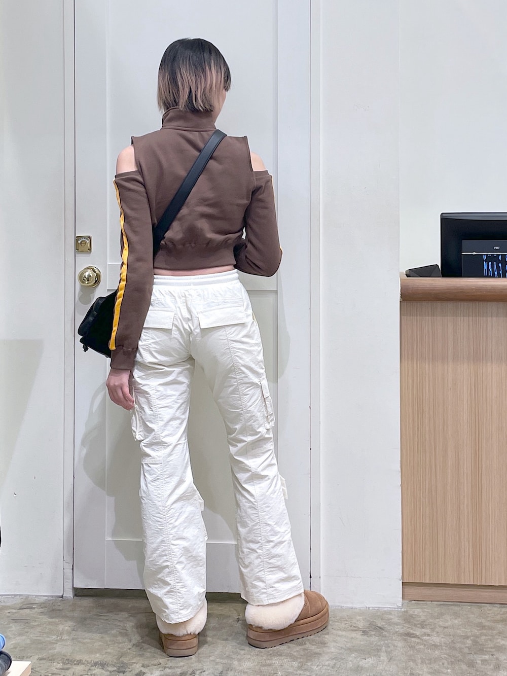ブラウン系のスウェット、ブラック系のショルダーバッグ、ホワイト系のその他パンツを着用したメンズの秋コーディネートの3枚目の写真