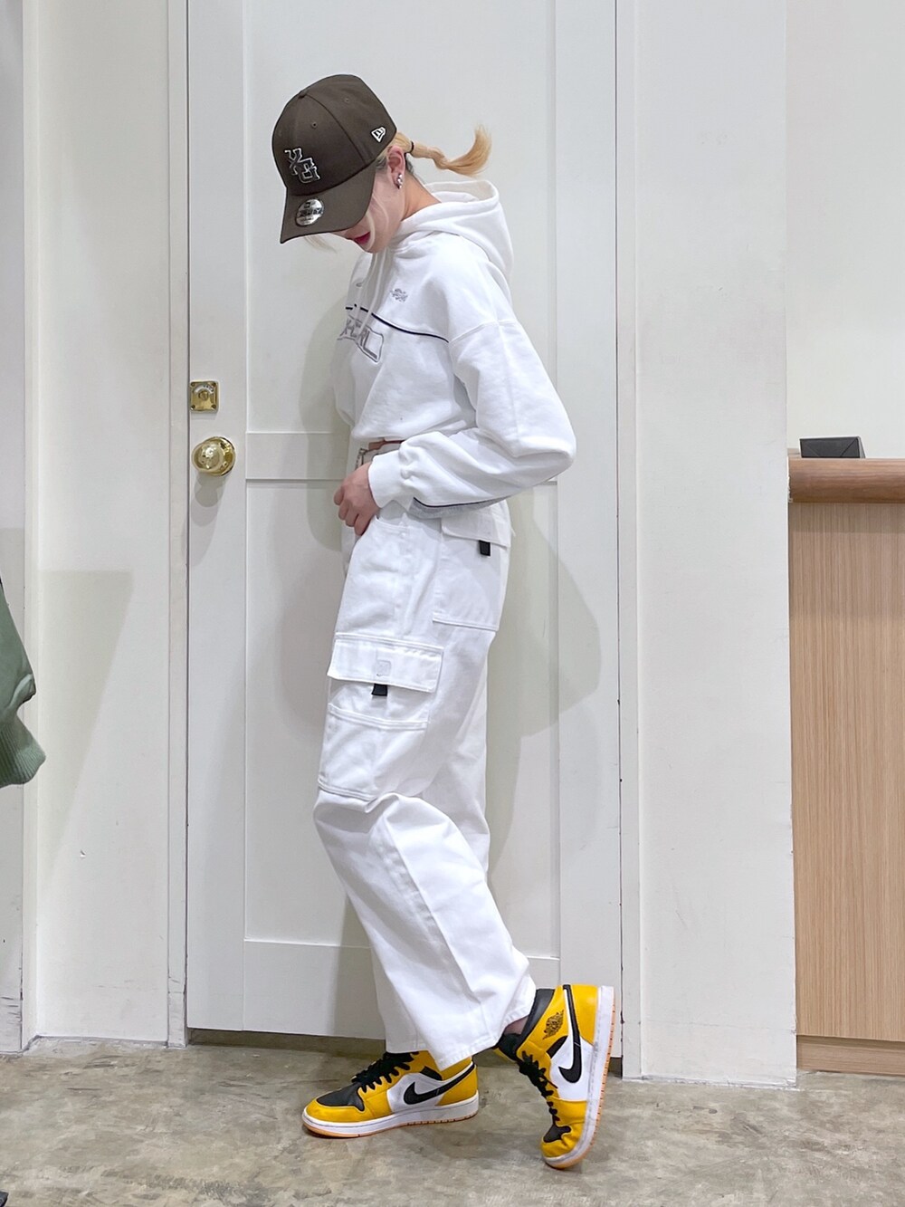 ホワイト系のカーゴパンツ、ホワイト系のパーカー、ホワイト系のベルトを着用したレディースの春コーディネートの3枚目の写真