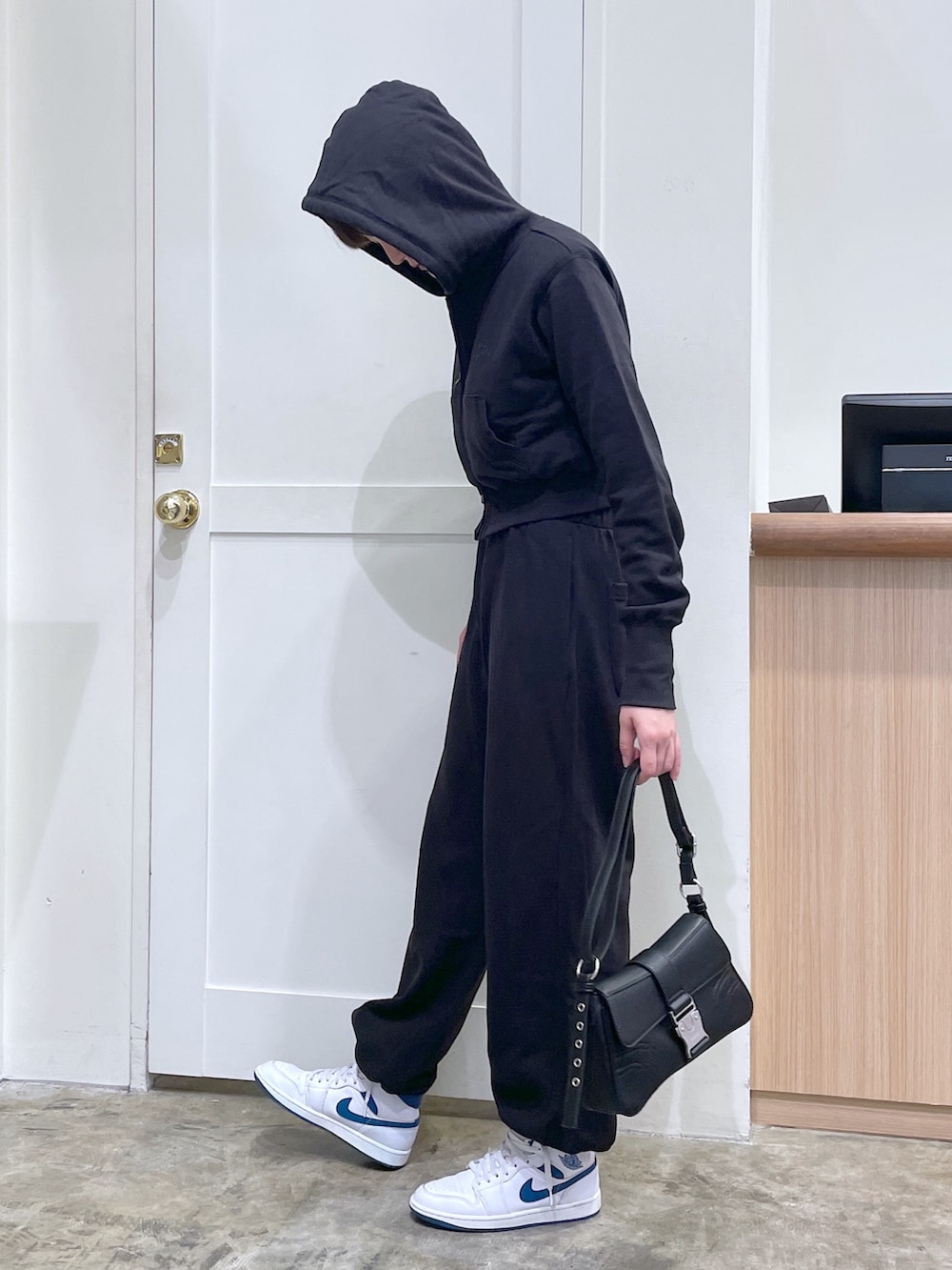 ブラック系のパーカー、ブラック系のスウェットパンツ、ブラック系のショルダーバッグを着用したメンズの秋コーディネートの2枚目の写真