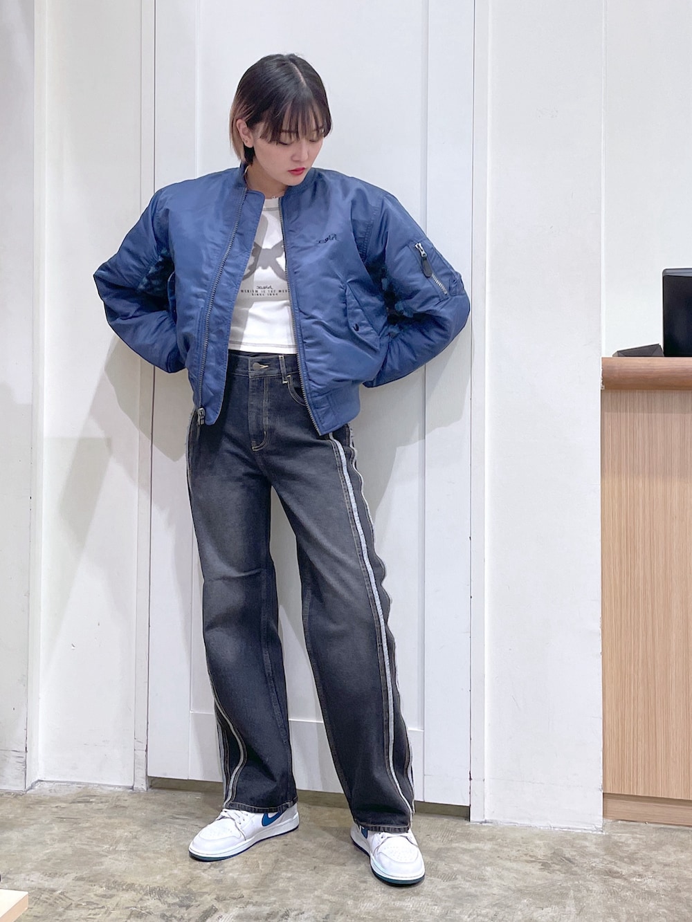 ブルー系のMA-1、ホワイト系のTシャツ/カットソー、ブラック系のデニムパンツを着用したメンズの秋コーディネートの2枚目の写真