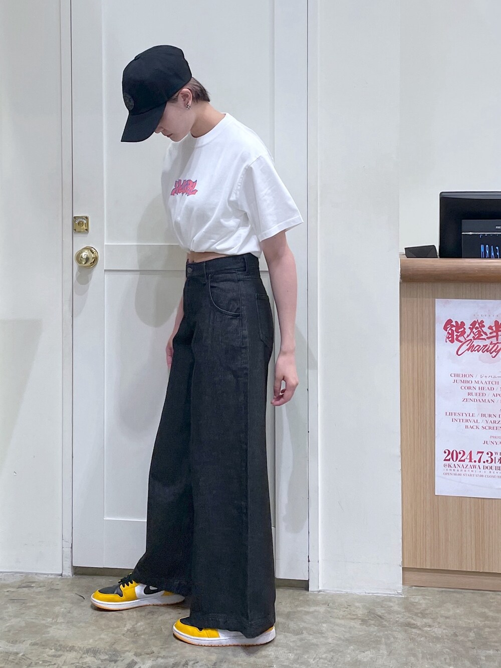 ブラック系のデニムパンツ、ホワイト系のTシャツ/カットソー、ブラック系のキャップを着用したメンズの夏コーディネートの3枚目の写真