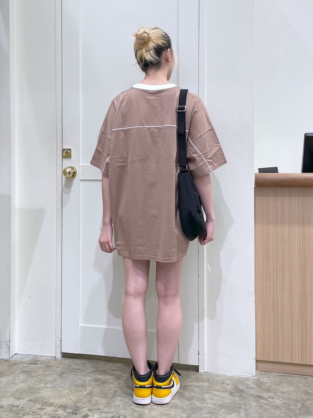 ブラウン系のワンピース、ブラック系のショルダーバッグ、ブラック系のキーホルダーを着用したメンズの春コーディネートの3枚目の写真