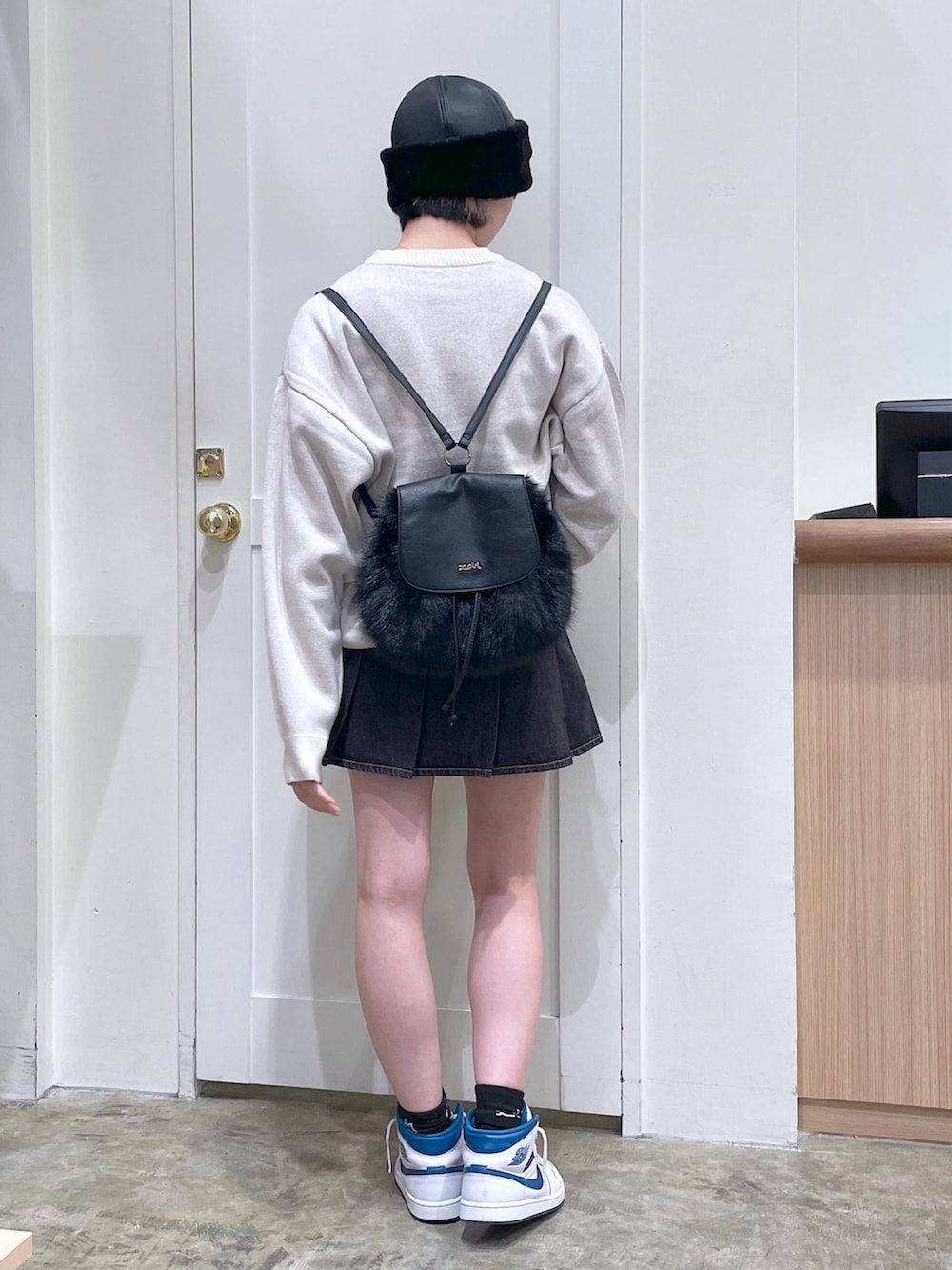 ホワイト系のニット/セーター、ブラック系のバックパック/リュック、ブラック系のデニムスカートを着用したメンズの秋コーディネートの4枚目の写真