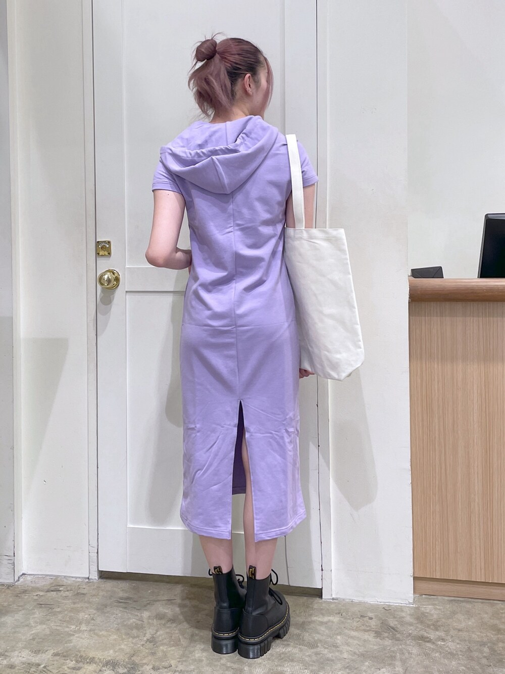 パープル系のワンピース、ホワイト系のトートバッグ、ブラック系のブーツを着用したメンズの春コーディネートの3枚目の写真