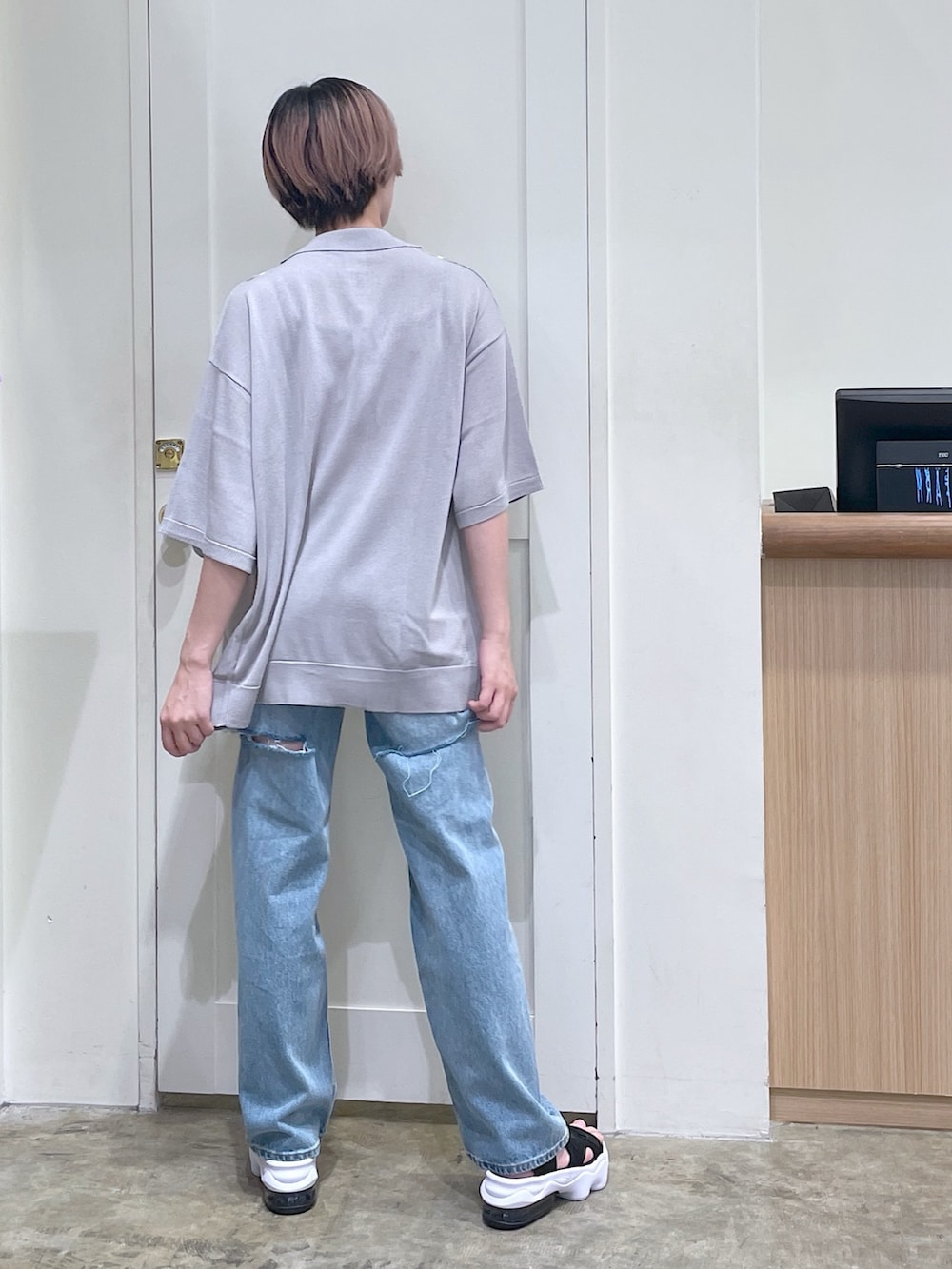 グレー系のポロシャツ、ホワイト系のキャミソール、ブルー系のデニムパンツを着用したメンズの夏コーディネートの4枚目の写真