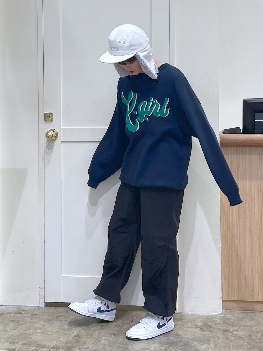 ブルー系のニット/セーター、ブラック系のその他パンツ、ホワイト系のキャップを着用したメンズの秋コーディネートの3枚目の写真