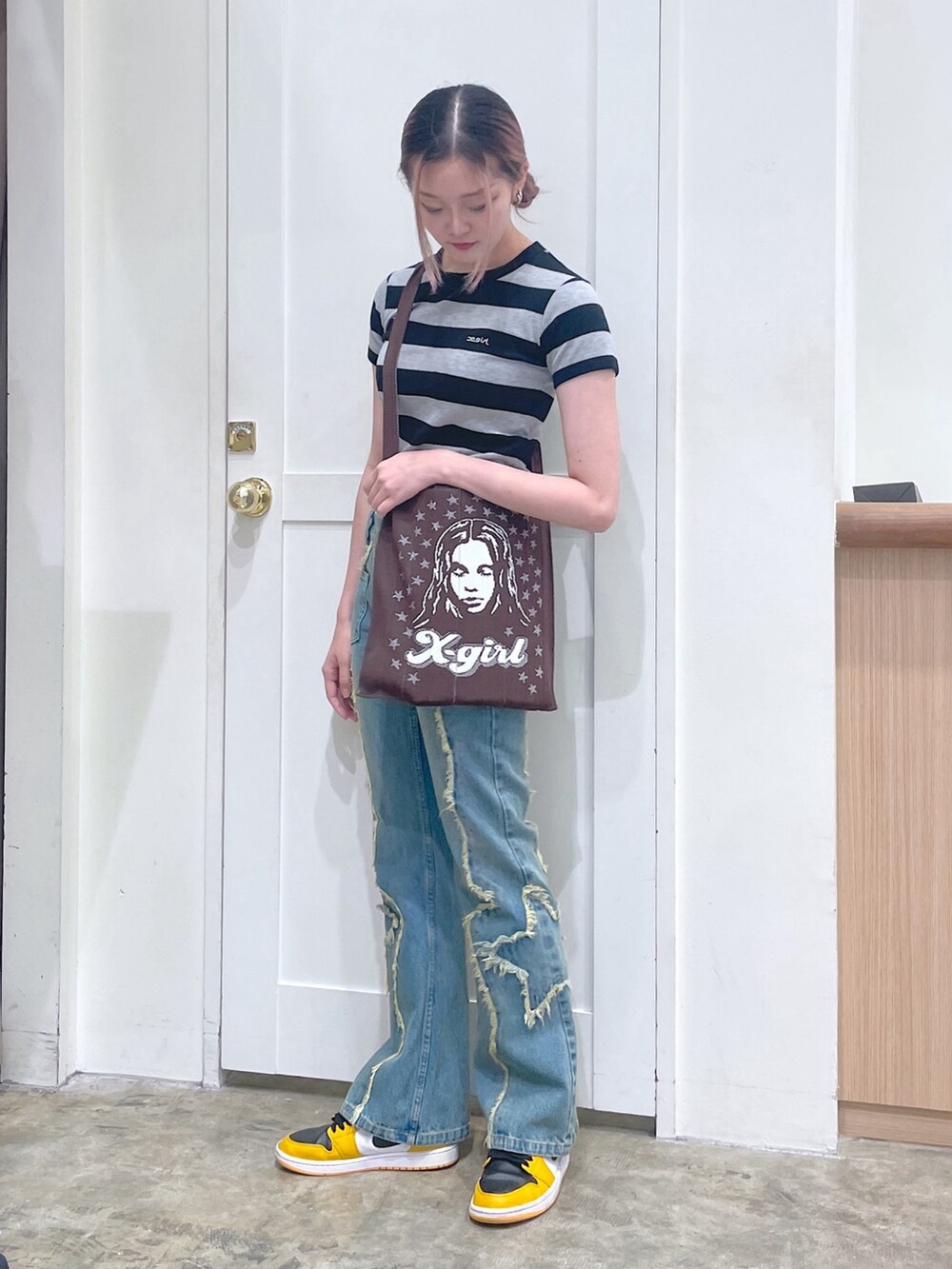 ブラック系のTシャツ/カットソー、ブラウン系のショルダーバッグ、ブルー系のデニムパンツを着用したメンズの春コーディネートの2枚目の写真