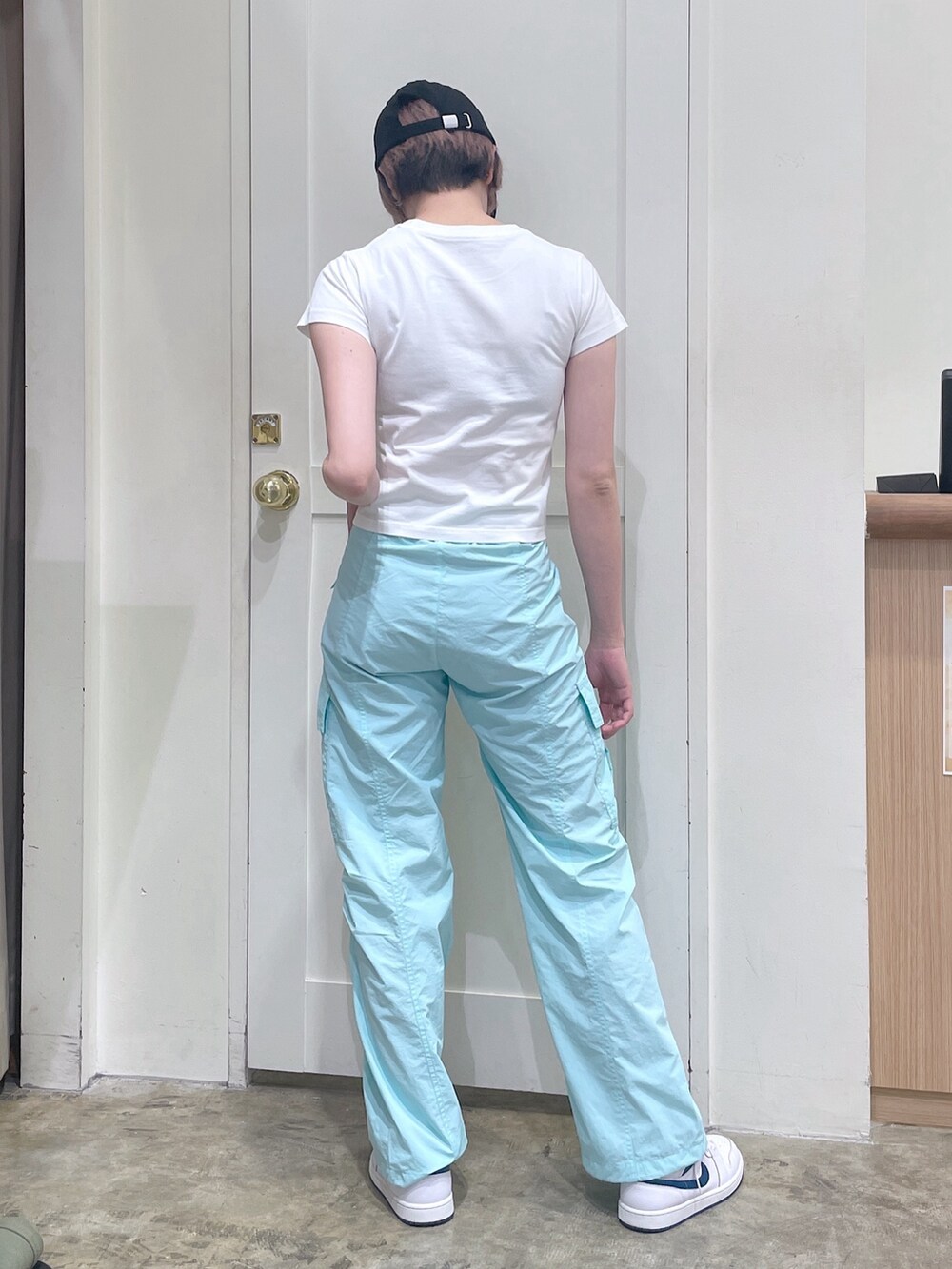 グリーン系のカーゴパンツ、ホワイト系のTシャツ/カットソー、ブラック系のキャップを着用したレディースの夏コーディネートの3枚目の写真