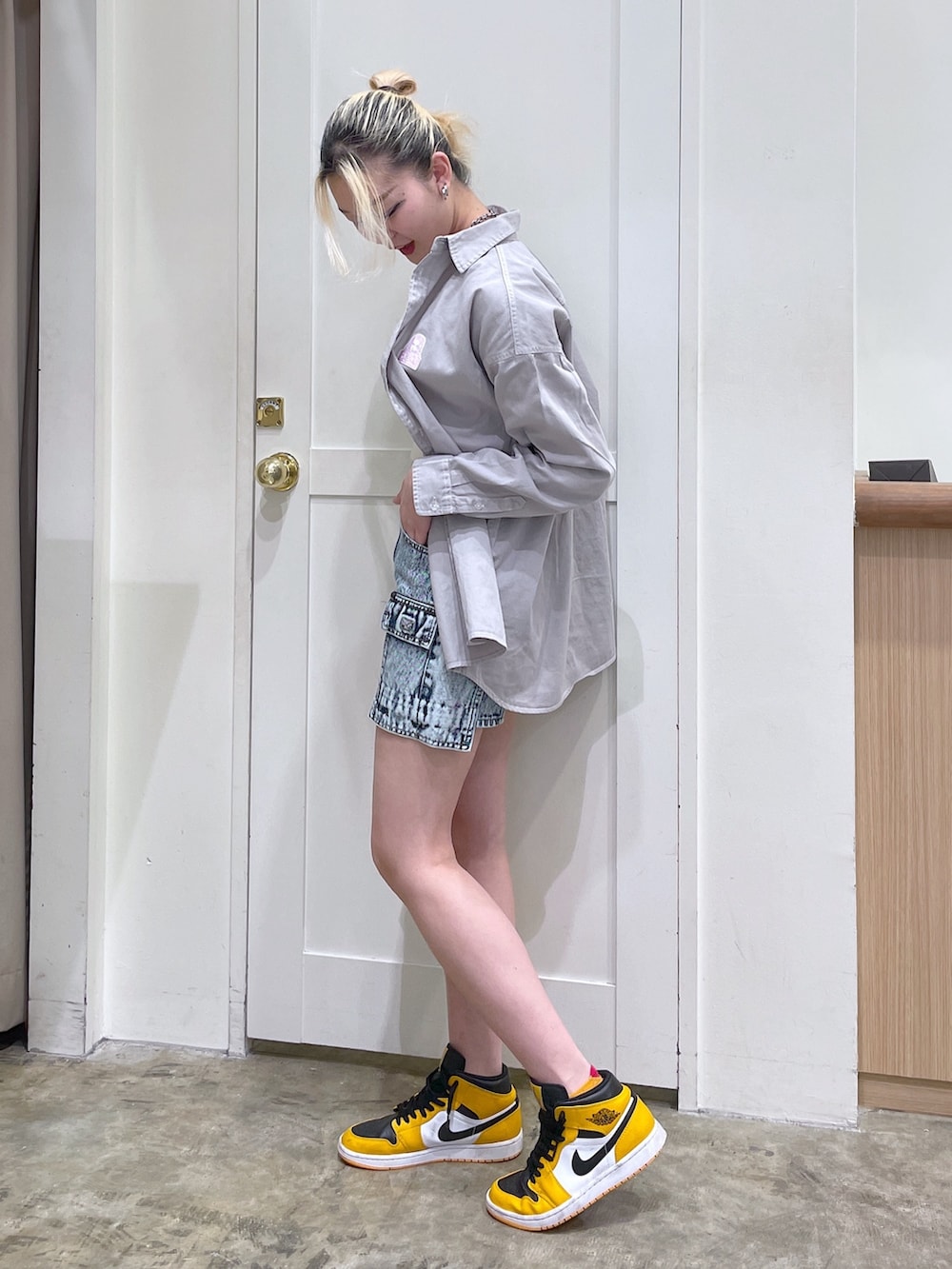 ブルー系のデニムパンツ、ホワイト系のスウェット、グレー系のシャツ/ブラウスを着用したレディースの春コーディネートの2枚目の写真