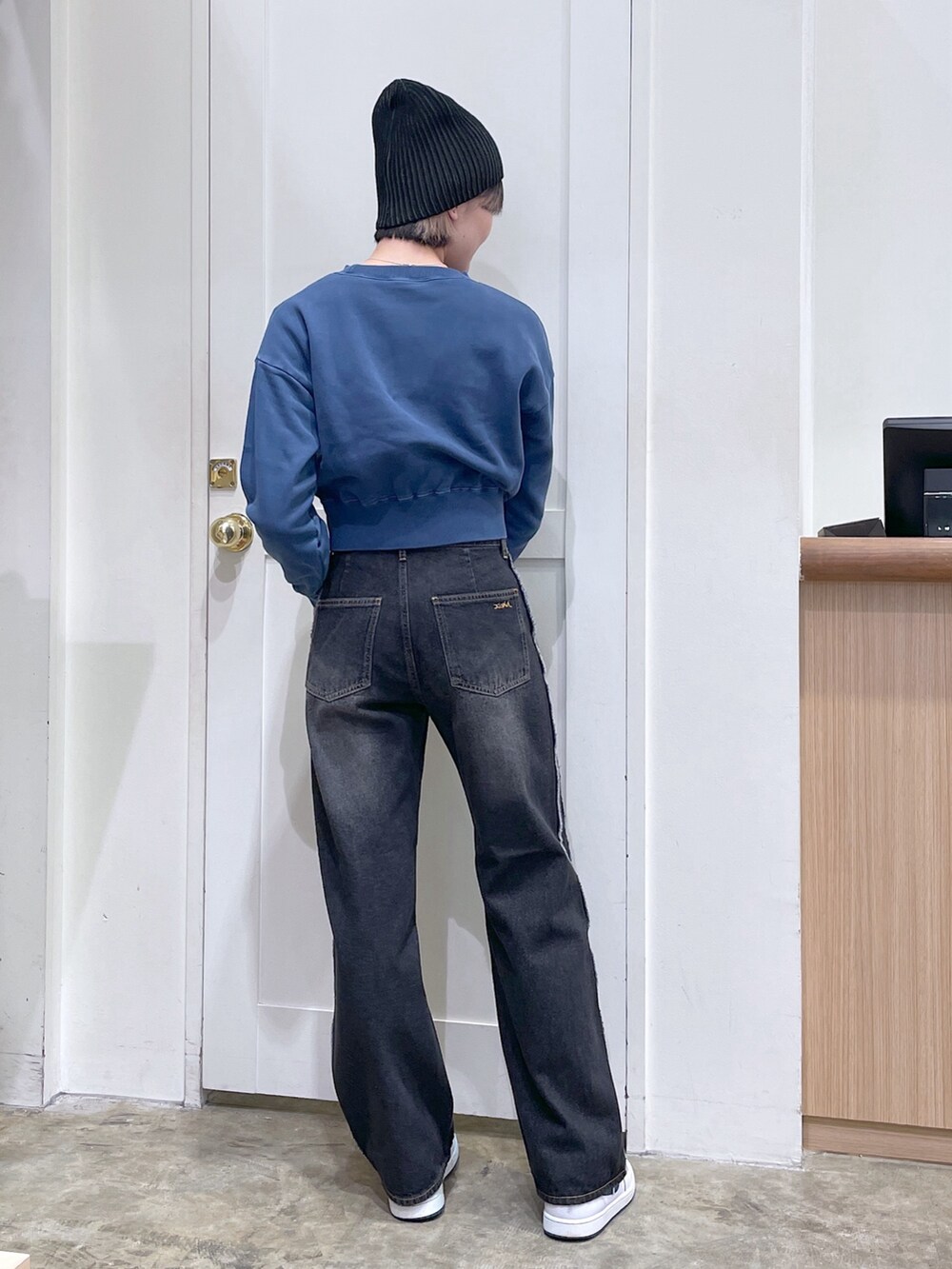 ブルー系のスウェット、ブラック系のデニムパンツ、ブラック系のニットキャップ/ビーニーを着用したメンズの秋コーディネートの3枚目の写真