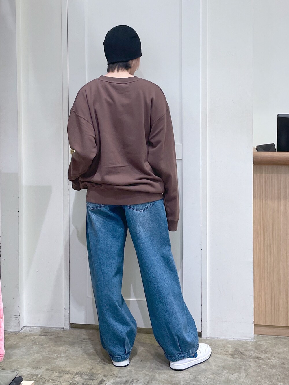 ブラウン系のスウェット、ブルー系のデニムパンツ、ブラック系のニットキャップ/ビーニーを着用したメンズの秋コーディネートの3枚目の写真