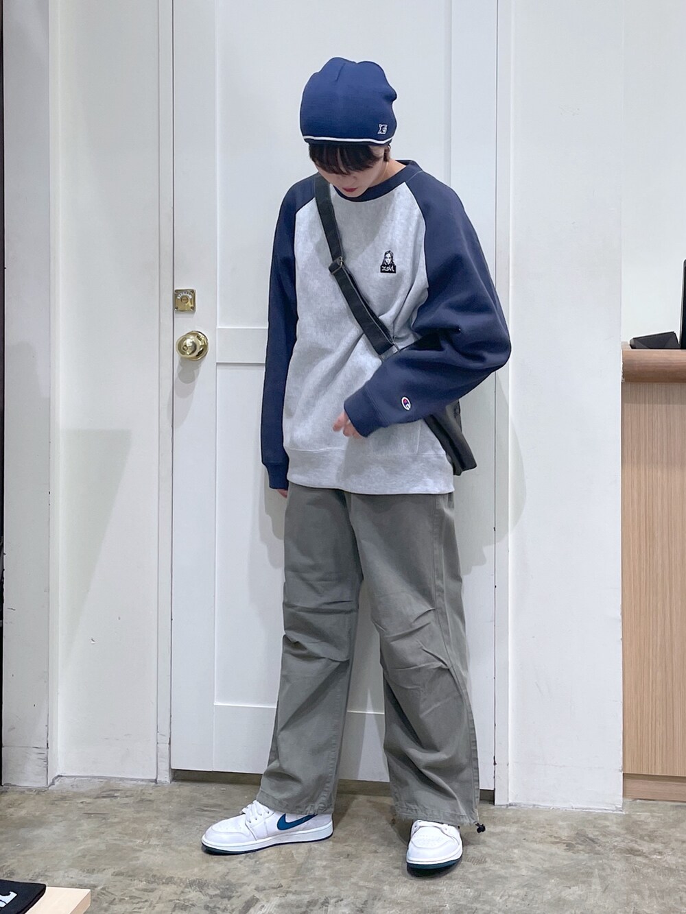 グレー系のスウェット、ブラック系のショルダーバッグ、グリーン系のその他パンツを着用したメンズの秋コーディネートの2枚目の写真