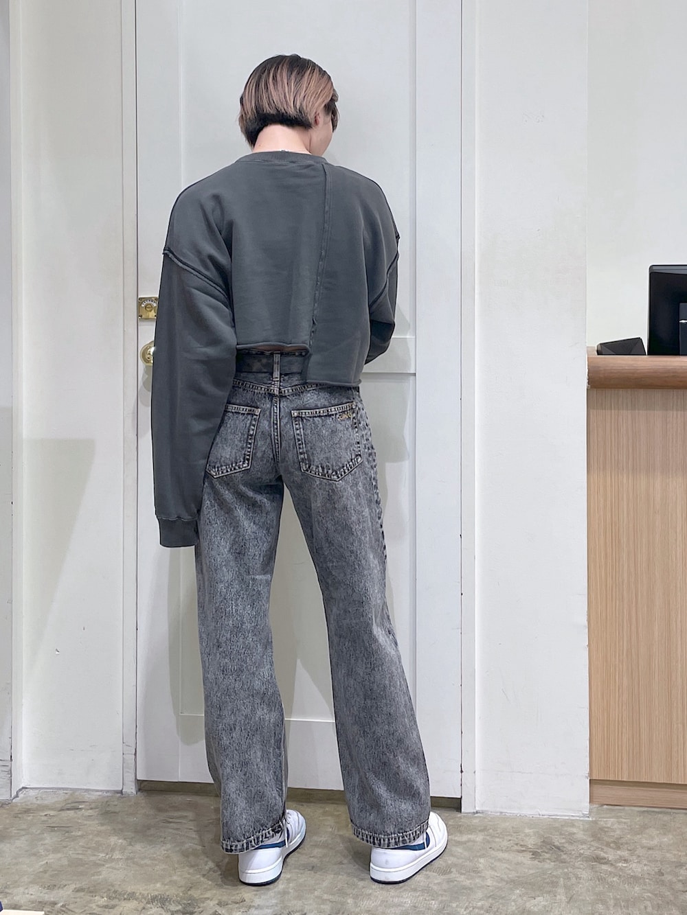 ブラック系のスウェット、ブラック系のデニムパンツ、ゴールド系のベルトを着用したメンズの秋コーディネートの3枚目の写真