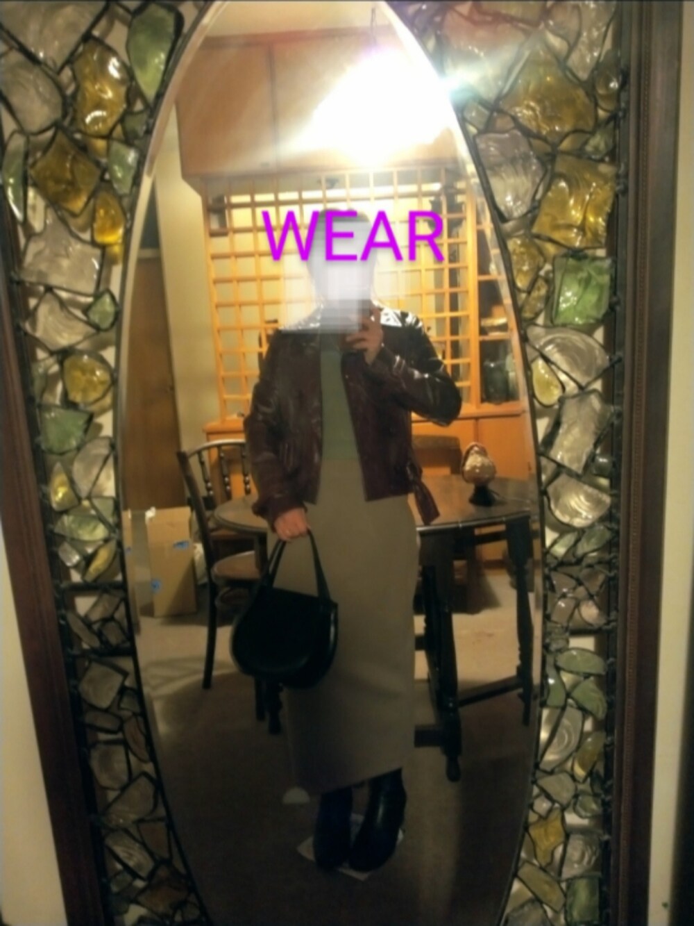 ブラック系のブーツ、ブラック系のハンドバッグ、グリーン系のスカートを着用したレディースの冬コーディネートの2枚目の写真