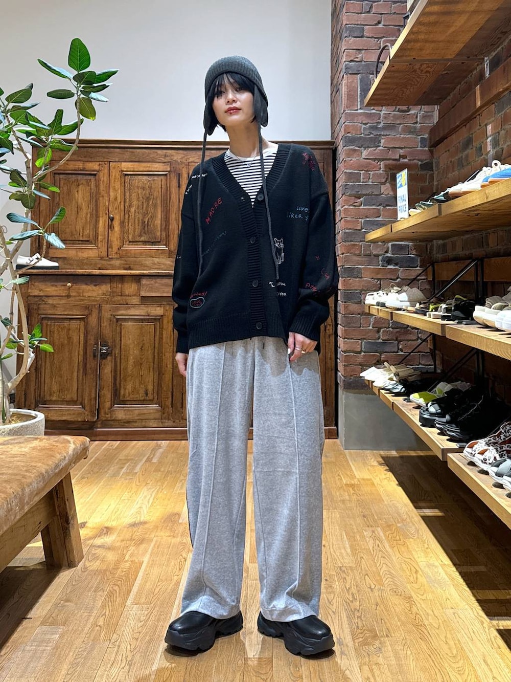 グレー系のその他パンツ、ブラック系のブーツ、ブラック系のカーディガン/ボレロを着用したレディースの秋コーディネートの2枚目の写真