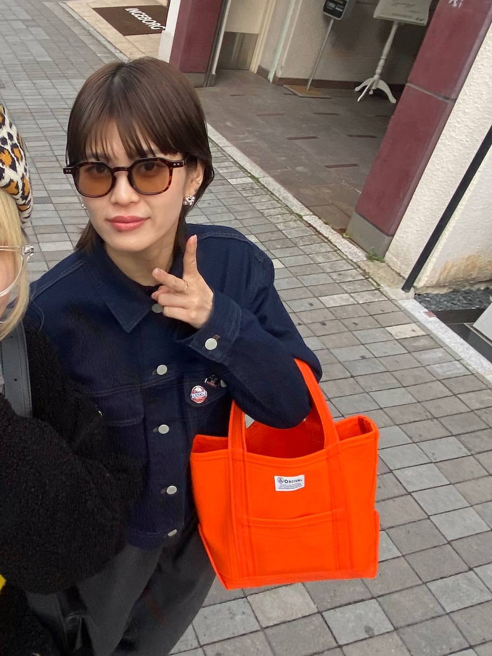 ホワイト系のスニーカーを着用したレディースの春コーディネートの3枚目の写真