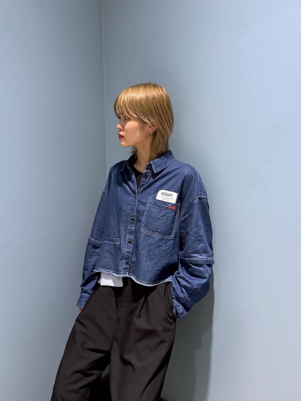 ブラック系のスラックスを着用したレディースの春コーディネートの2枚目の写真