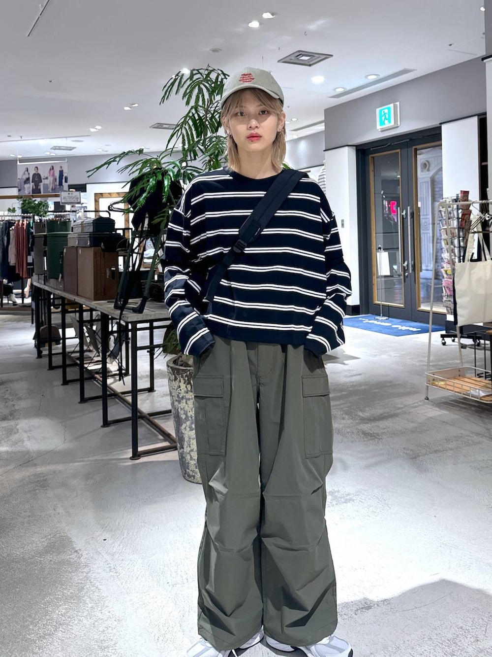 グリーン系のカーゴパンツ、ブラック系のTシャツ/カットソー、グレー系のスニーカーを着用したメンズの春コーディネートの5枚目の写真