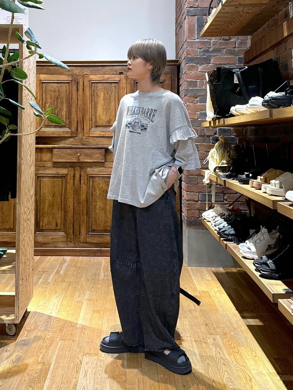 ブラック系のデニムパンツ、グレー系のバックパック/リュック、グレー系のTシャツ/カットソーを着用したレディースの夏コーディネートの2枚目の写真