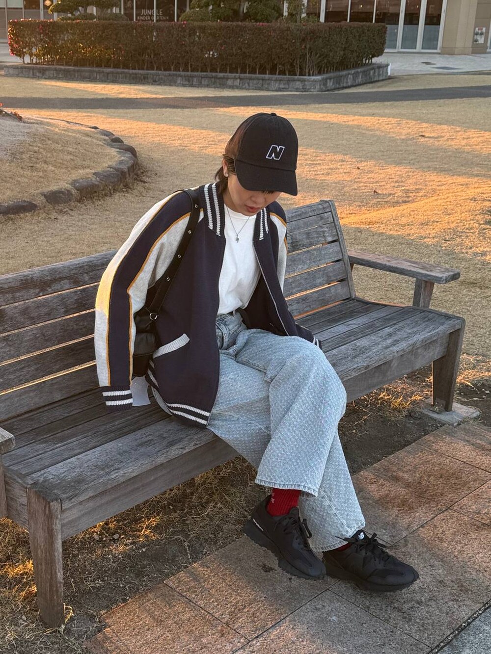 ホワイト系のTシャツ/カットソー、ブラック系のショルダーバッグ、ブルー系のデニムパンツを着用したレディースの冬コーディネートの3枚目の写真