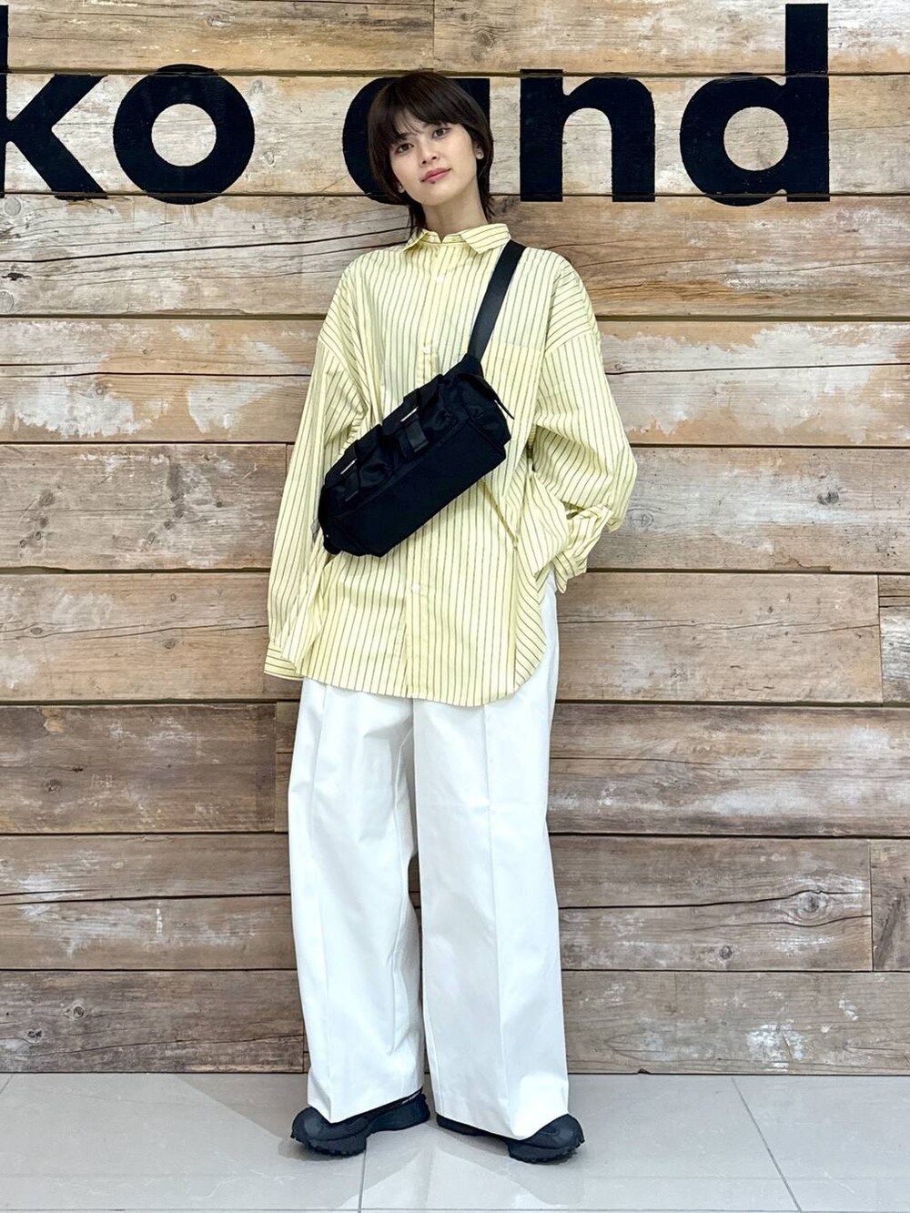 ベージュ系のチノパンツ、イエロー系のシャツ/ブラウス、ブラック系のスニーカーを着用したレディースの冬コーディネートの2枚目の写真