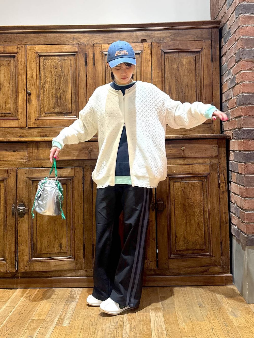 ホワイト系のブルゾン、ブルー系のニット/セーター、グリーン系のTシャツ/カットソーを着用したレディースの冬コーディネートの4枚目の写真