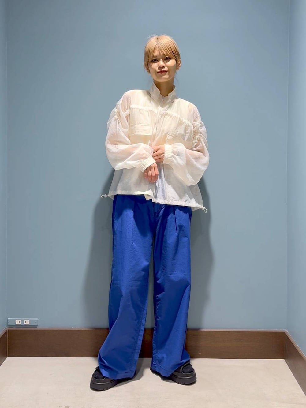 ベージュ系のタンクトップ、ブルー系のその他パンツ、ホワイト系のブルゾンを着用したレディースの春コーディネートの7枚目の写真